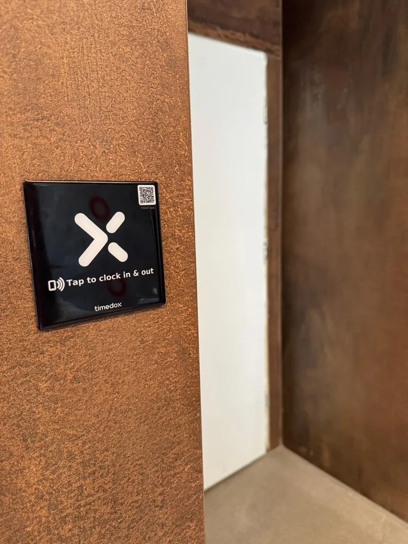 A Timedox NFC sticker mounted next to a doorway